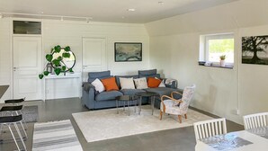 A modern living room with a grey sofa, a white coffee table, and a patterned rug. - Cozy home in Lammhult with sauna (Lammhult)