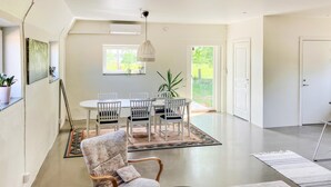 A modern dining area with a round table and chairs, a large window, and a view of the outdoors. - Cozy home in Lammhult with sauna (Lammhult)