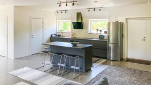 A modern kitchen with a central island, stainless steel appliances, and a minimalist design. - Cozy home in Lammhult with sauna (Lammhult)