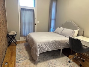 2 habitaciones, escritorio y tabla de planchar con plancha