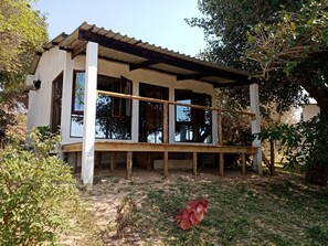 Ein eingeschossiges Gebäude mit einer Holzterrasse und großen Fenstern.