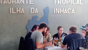 L'interno di un ristorante con tavoli e sedie, una bacheca dei menu e un muro con il nome del ristorante.