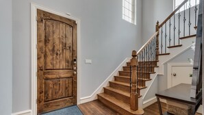 Eine Holztreppe mit Handlauf und Fußmatte.