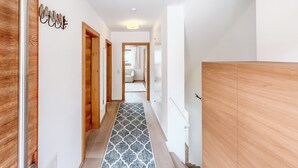 A hallway with wooden doors, a patterned floor, and a wardrobe. - Pool-chalet - Zentral in Seefeld (Seefeld in Tirol)