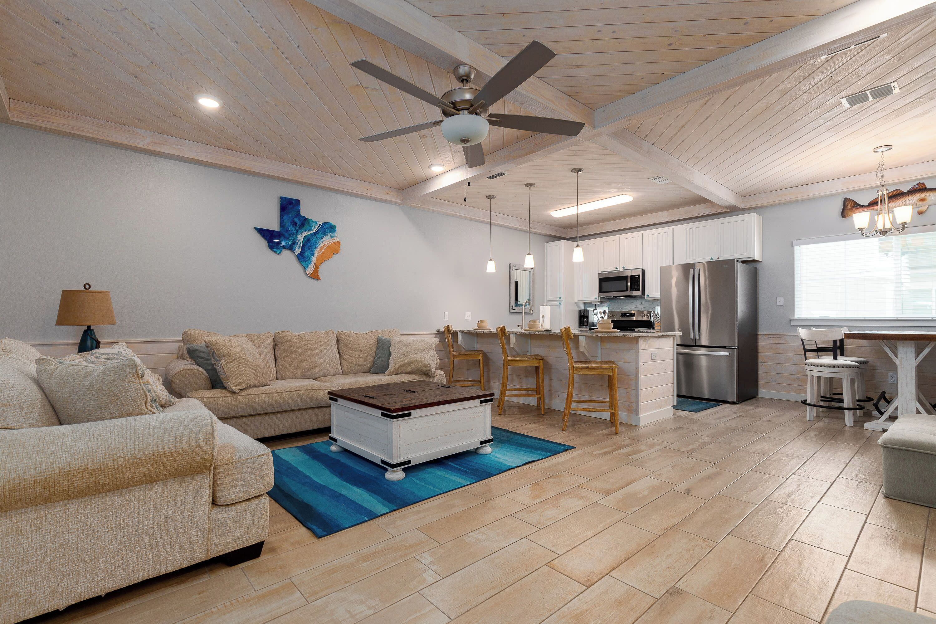Un salon spacieux avec un canapé, une table basse et un ventilateur de plafond.