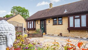 A residential house with a tiled roof, a brick facade, and a front garden with various plants and flowers. - 2 bedroom accommodation in Reepham (Reepham)