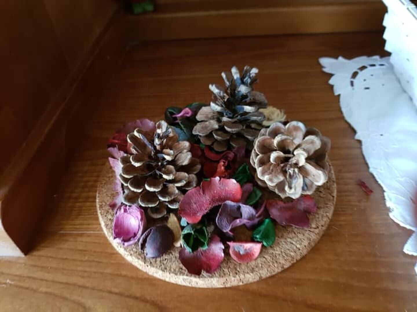 A decorative pine cone arrangement on a wooden surface.