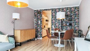 A compact living space with a dining area, a sofa, a coffee table, and a bookshelf. - Lovely apartment in Oostende with WiFi (Oostende)