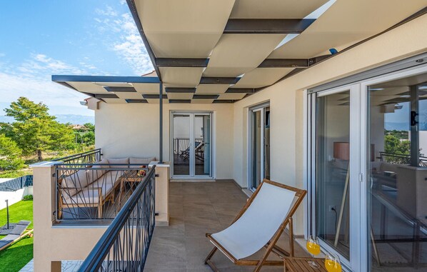 A balcony with a view of the landscape, a chair, and a table with glasses. - Beautiful home in Vrsi (Vrsi)