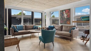Ein geräumiges Wohnzimmer mit großen Fenstern, einem Pool und einem modernen Deckenstil.