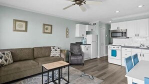 Un salon moderne comprenant un canapé, une table basse et un coin repas avec une table et des chaises.