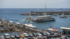 A marina with boats, a ferry, and a docked ship.