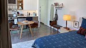 A compact hotel room with a kitchenette, a dining area, and a bed. - Modern cozy Santa Monica Studio w/ Patio - 18 blocks from the beach! (Santa Monica)