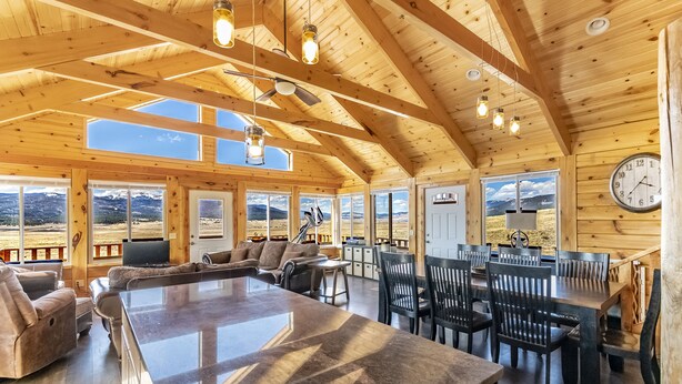 A spacious wooden interior with a large central island, dining area, and seating. - Mountain House Sleeps 18, Mins to Ski, Hike, Golf, Fish; Generator;  Fenced Yard (Angel Fire)