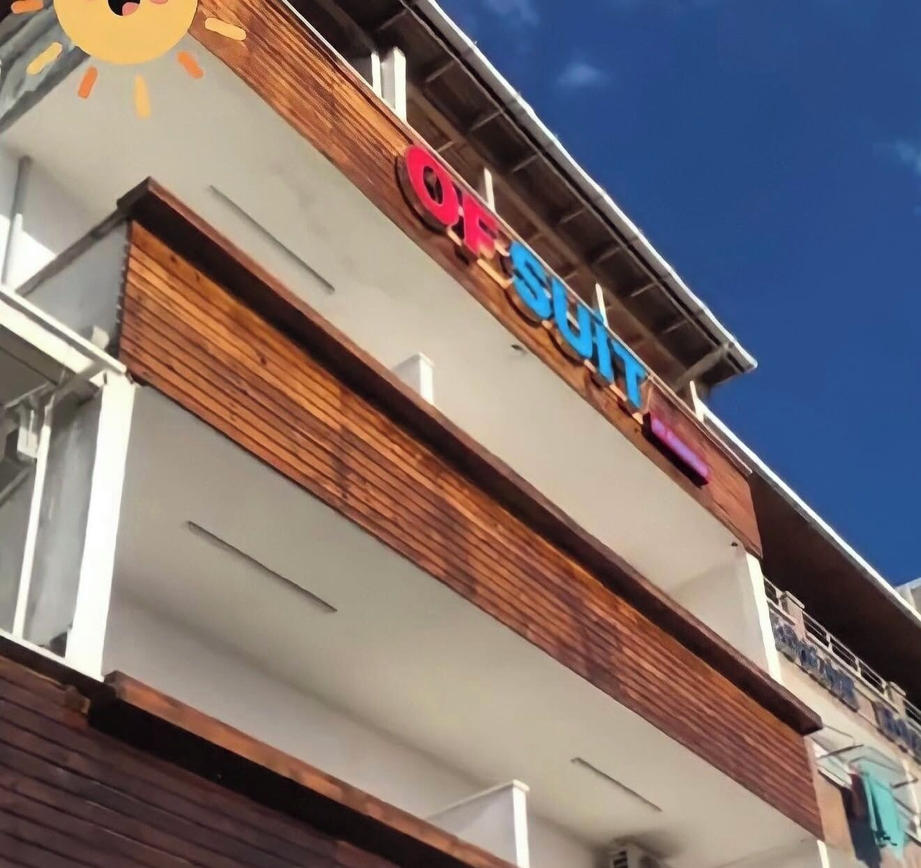 Un edificio con un letrero que dice 'OFFSHORE' y un balcón con barandilla.