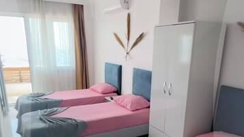 A hotel room with two beds, a wardrobe, and a decorative wall piece.