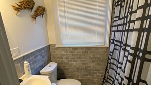 Une salle de bain équipée de toilettes, d’un lavabo et d’un rideau de douche.