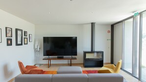 Una sala moderna con televisor de pantalla plana, chimenea y asientos cómodos.