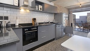 A modern kitchen with a built-in oven, a dishwasher, and a granite countertop. - Manhattan on Coral 7 (Cape Town)