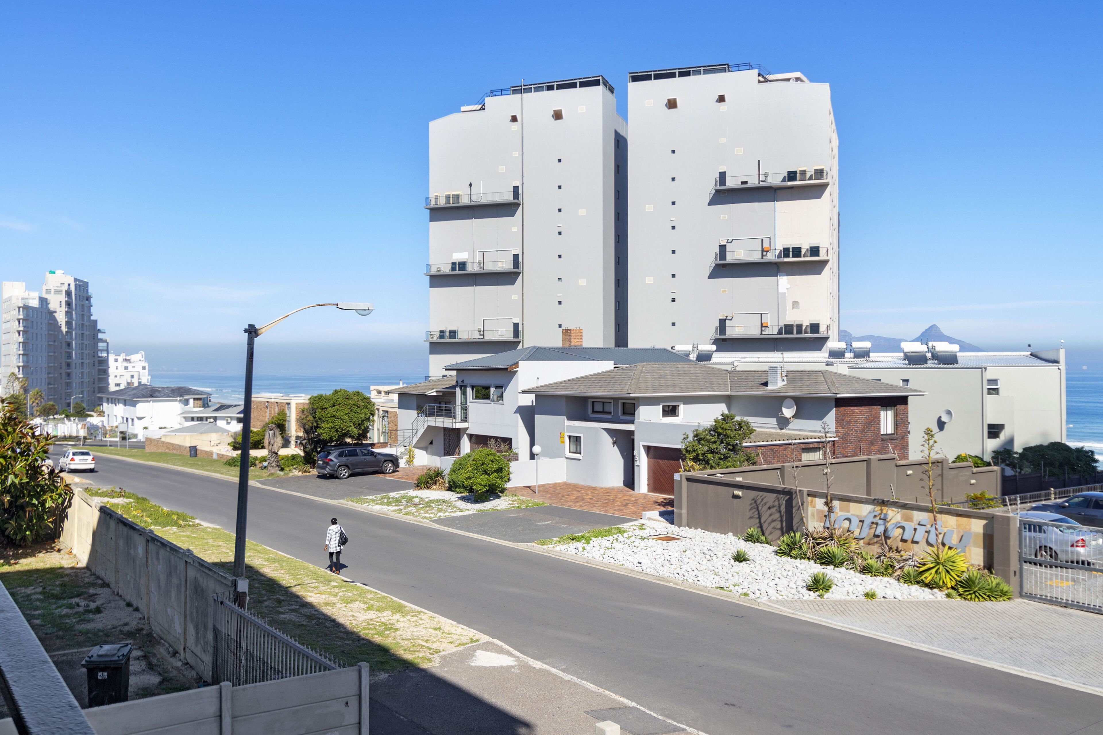 Un bâtiment moderne doté d’un toit plat, d’un garage et d’une enseigne sur laquelle est inscrit le mot « Infini ».
