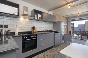 Uma cozinha moderna com forno embutido, lava-louças e bancada de granito.