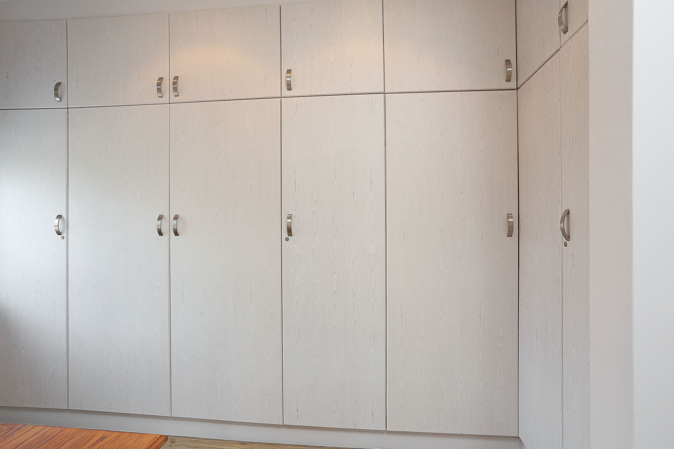 A large, white, wooden wardrobe with multiple doors and handles.