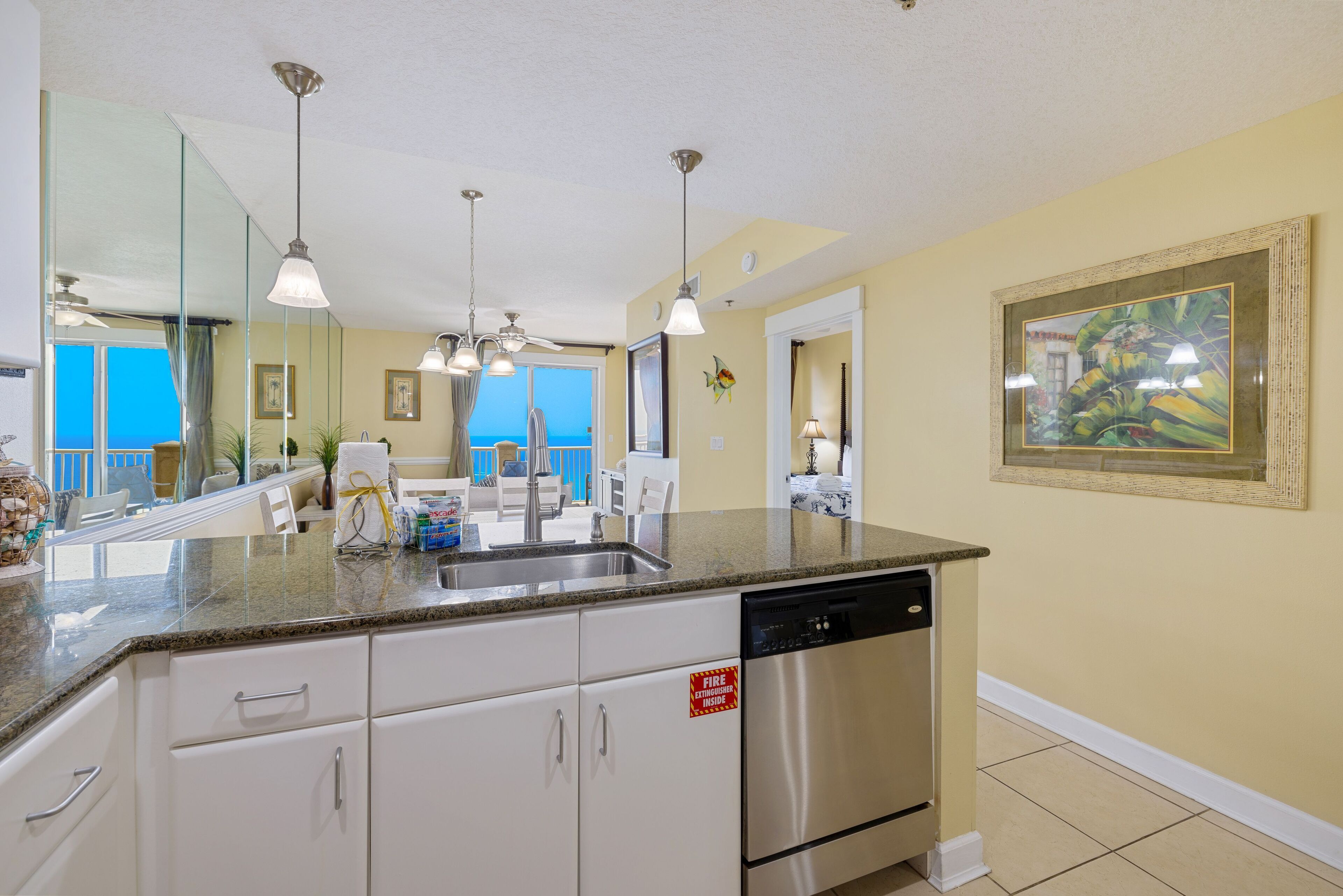 A modern kitchen with granite countertops, stainless steel appliances, and pendant lighting.