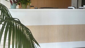 Una recepción con pared de paneles de madera y el letrero "WHISPERING SANDS".