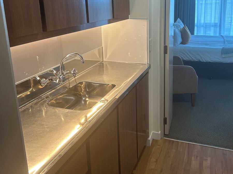 A compact kitchen with stainless steel appliances and wooden cabinets.
