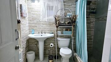 Een douche, handdoeken, zeep, shampoo