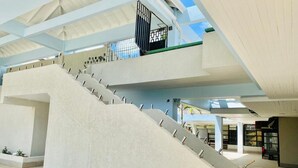 Een modern interieur met een opvallende trap, dakraam en een receptie.