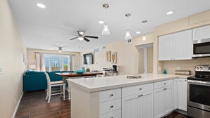 A modern kitchen with white cabinets, a stainless steel oven, and a central island. - La Mirage Condo 101 Beachfront Condo Resort with Private Boardwalk (Port Aransas)