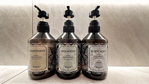 Three bottles of Kracie body care products: conditioner, shampoo, and body soap, with botanical materials. - hotelbella (Tokyo)