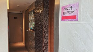 A reception area with a sign indicating 'Front Reception' and a door labeled '103'. - hotelbella (Tokyo)