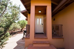 Una entrada de casa con puerta, escalones y barandilla.