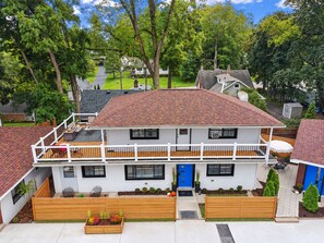 A two-story house with a balcony, a garage, and a well-maintained garden.