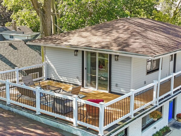 A small, single-story house with a covered patio, a sliding glass door, and a fenced deck area.