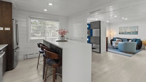 Une cuisine moderne dotée d’un îlot central, de tabourets de bar et d’un réfrigérateur.