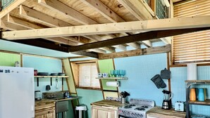 Una cocina compacta con armarios de madera, una estufa y un refrigerador.