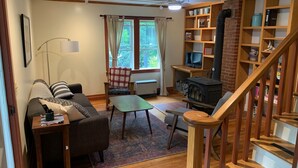A cozy living room with a sofa, a coffee table, a fireplace, and a bookshelf. - Cozy farmhouse with jacuzzi 10 min from Lansing, NC and Grayson Highlands (Lansing)