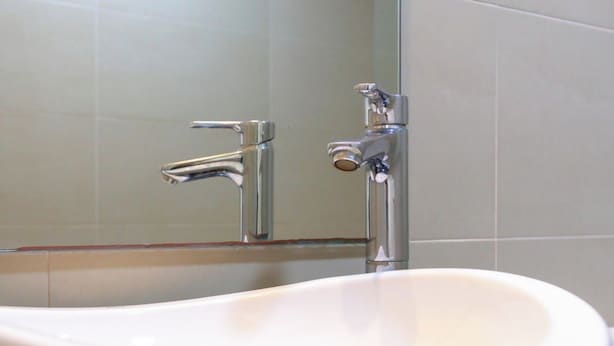 Un évier en céramique blanche avec un robinet chromé, dans une salle de bain.