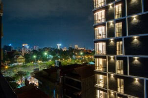 Een verlicht stadsbeeld bij nacht met gebouwen en straatverlichting.