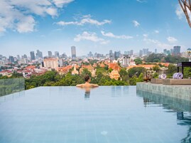 Iemand ontspant in een dakzwembad met een panoramisch uitzicht over de stad.