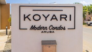 A sign for "Koyari Modern Condos Aruba" with a mailbox and a number "1-5" below it. - Koyari Modern Condos 3 w Private Roof Deck (Noord)