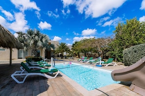 A pool area with lounge chairs and a slide. - Koyari Modern Condos 3 w Private Roof Deck (Noord)