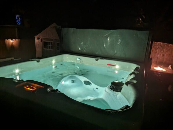 Un jacuzzi con revestimiento de madera y cerramiento de vidrio.
