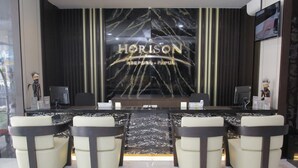 A reception desk with a marble top and a large sign reading "HORIZON ABEPURA - PAPUA". - Horison Abepura (Jayapura)