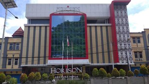 A modern building with a large glass facade, the name 'HORIZON' prominently displayed, and a sign indicating 'ABEPURA-PAPUA'. - Horison Abepura (Jayapura)