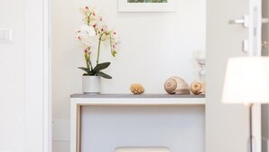 A bathroom with a white sink, a potted orchid, seashells, and a framed picture on the wall. - The House of Corals (Monopoli)