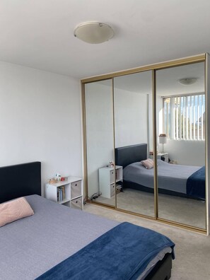 Relax in a serene space with a large mirror, single bed, and comfortable seating areas.